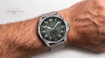 Junghans Meister Pilot with an olive green dial, scalloped cockpit bezel, triple date under twelve and luminous sword hands on a steel mesh bracelet