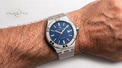 Maurice Lacroix Aikon automatic with a blue textured dial, white bar markers, a date at three and a steel mesh bracelet on the wrist
