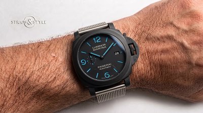 Panerai Luminor Marina with a matte black dial, blue luminous numerals, crown-protection bridge and a date at three on a Straps&Style mesh bracelet