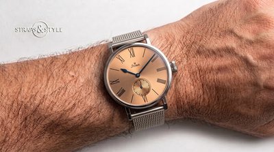 STOWA Bauhaus dress watch with a salmon copper sunburst dial, black Roman numerals, blued hands and small seconds at six on a Straps&Style mesh bracelet