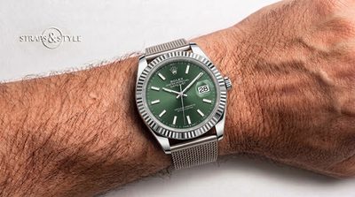 Rolex Datejust with a sunburst olive green dial, fluted bezel and a date window beneath a cyclops lens on a Straps&Style mesh bracelet
