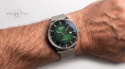 Mido Commander automatic with a green gradient dial, slim silver bar markers, a curved date window at three and a grey mesh bracelet on the wrist