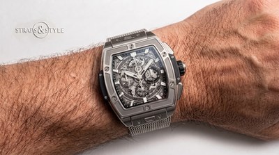 Hublot tonneau chronograph with a skeletonised dial, date between four and five and a bezel with six H-shaped screws on a Straps&Style mesh bracelet
