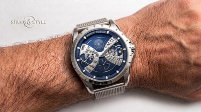 Roger Dubuis bi-retrograde calendar with a deep blue dial, silver retrograde arcs, exposed calendar gears and small seconds at six on a Straps&Style mesh bracelet