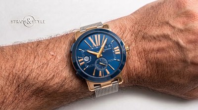 Ulysse Nardin dual-time watch with a rose-gold-tone case, sunburst blue dial, Roman numerals, second time zone at nine and big date at two on a Straps&Style mesh bracelet