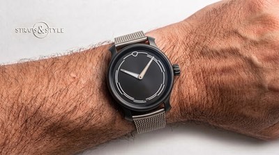 Ming watch in a matte bead-blasted dark case with a minimalist charcoal dial, printed concentric tracks and luminous hands on a Straps&Style mesh bracelet