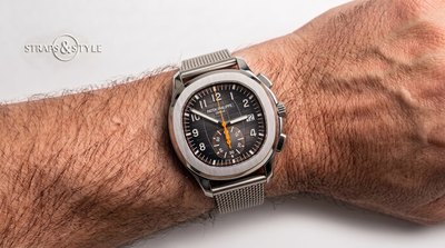 Patek Philippe Aquanaut chronograph with a charcoal embossed dial, orange chronograph hand and a date at three on a Straps&Style mesh bracelet