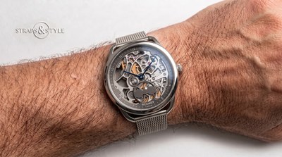 Slim d'Hermès skeletonised moonphase watch with exposed gear train and blued hands on a Straps&Style mesh bracelet