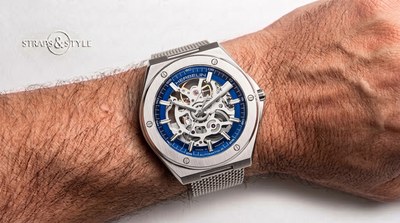 Michel Herbelin Captain skeleton automatic with a blue chapter ring, exposed movement and a steel mesh bracelet on the wrist