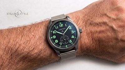Vertex Dirty Dozen field watch with a black dial, glowing green numerals, syringe hands and small seconds at six on a Straps&Style mesh bracelet