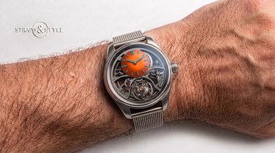 H. Moser & Cie skeletonised watch with a bright orange offset subdial and blue indices on a Straps&Style mesh bracelet