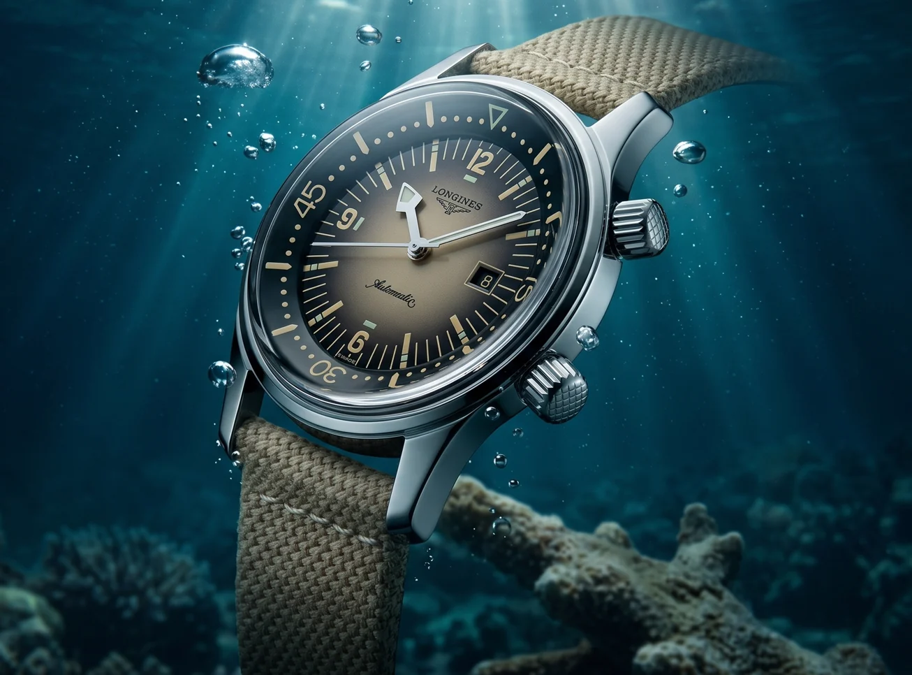 Diver's watch on a woven beige sailcloth strap suspended in sunlit underwater water