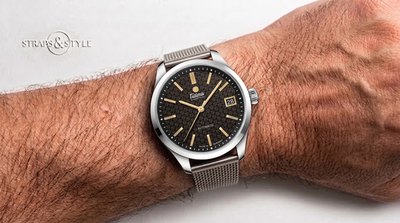 Tutima automatic with a dark brown patterned dial, gold-tone indices and date at three on a Straps&Style mesh bracelet