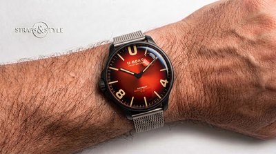 U-Boat Darkmoon in black-coated steel with a crimson red fumé dial, floating bubble and left-hand crown on a Straps&Style mesh bracelet