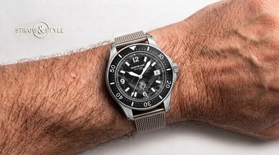 Montblanc diver with a black textured glacier dial, white luminescent numerals, a date at three and a black dive bezel on a Straps&Style mesh bracelet