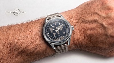 Raymond Weil worldtimer with a slate blue dial embossed with a world map, 24-hour ring, city bezel and a date at six on a Straps&Style mesh bracelet