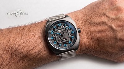 Hermès H08 skeleton in brushed dark titanium with cyan numerals and hand accents on a Straps&Style mesh bracelet