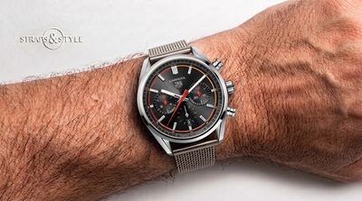 TAG Heuer chronograph with a charcoal black dial, three silver subdials, a date at six and a polished fixed bezel on a Straps&Style mesh bracelet