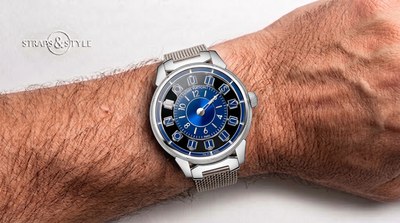 Louis Vuitton Tambour with a black dial, twelve blue-toned letter tiles spelling the brand name around a blue sunburst centre and a steel mesh bracelet on the wrist
