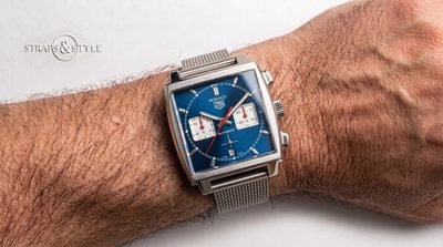 TAG Heuer Monaco automatic chronograph with a square steel case, iconic blue dial, white subdials and red accents on a Straps&Style mesh bracelet
