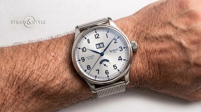 Hanhart 1882 with silver-white dial, blued hands, blue numerals, twin-aperture date at twelve and power-reserve gauge at six on a Straps&Style mesh bracelet