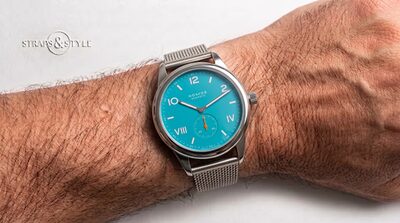 NOMOS Glashütte Club Campus with a turquoise California-style dial, Arabic and Roman numerals and an orange small-seconds hand on a Straps&Style mesh bracelet