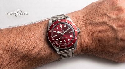Tudor Black Bay with a deep burgundy red dial, matching red dive bezel, Master Chronometer text and a date at three on a Straps&Style mesh bracelet