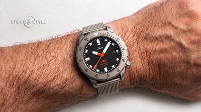 Sinn U50 diver with a matte black dial, a black and red rotating dive bezel, date at three and a four o'clock crown on a Straps&Style mesh bracelet