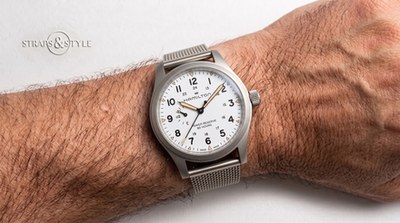 Hamilton Khaki watch with white dial, brushed grey case and a power-reserve indicator between nine and ten on a Straps&Style mesh bracelet