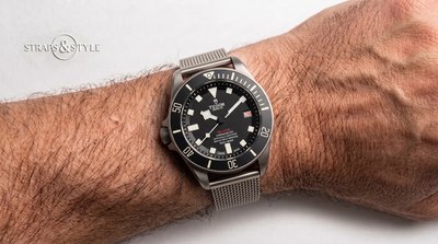 Tudor Pelagos chronometer with a matte black dial, red Pelagos text, date at three and a rotating dive bezel on a Straps&Style mesh bracelet